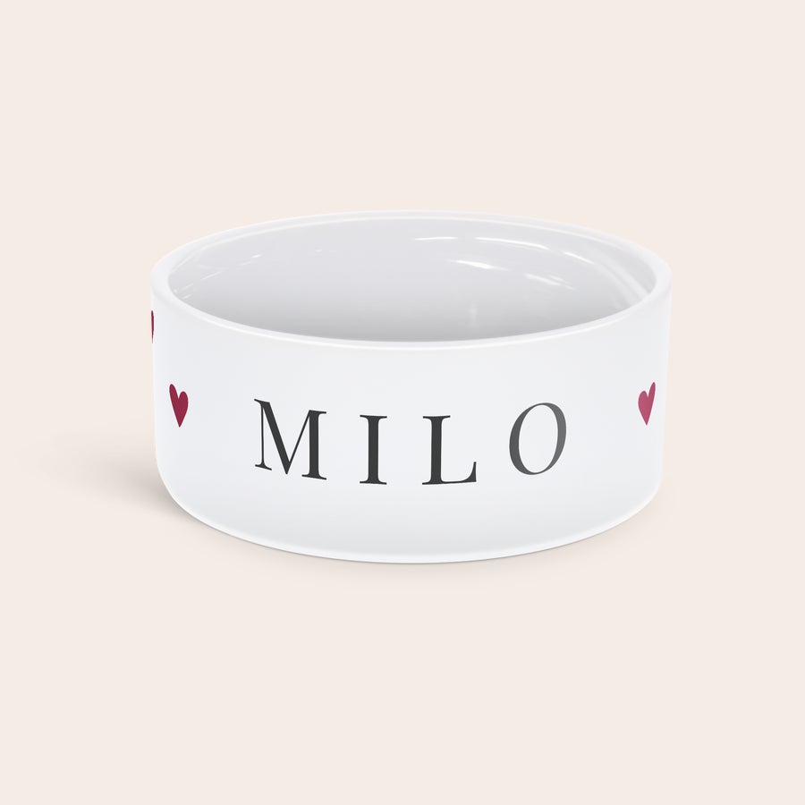 Personalizirana skleda za hrano za hišne ljubljenčke Bela personalizirana keramična skleda za hrano za hišne ljubljenčke z natisnjenim imenom MILO in srčki.