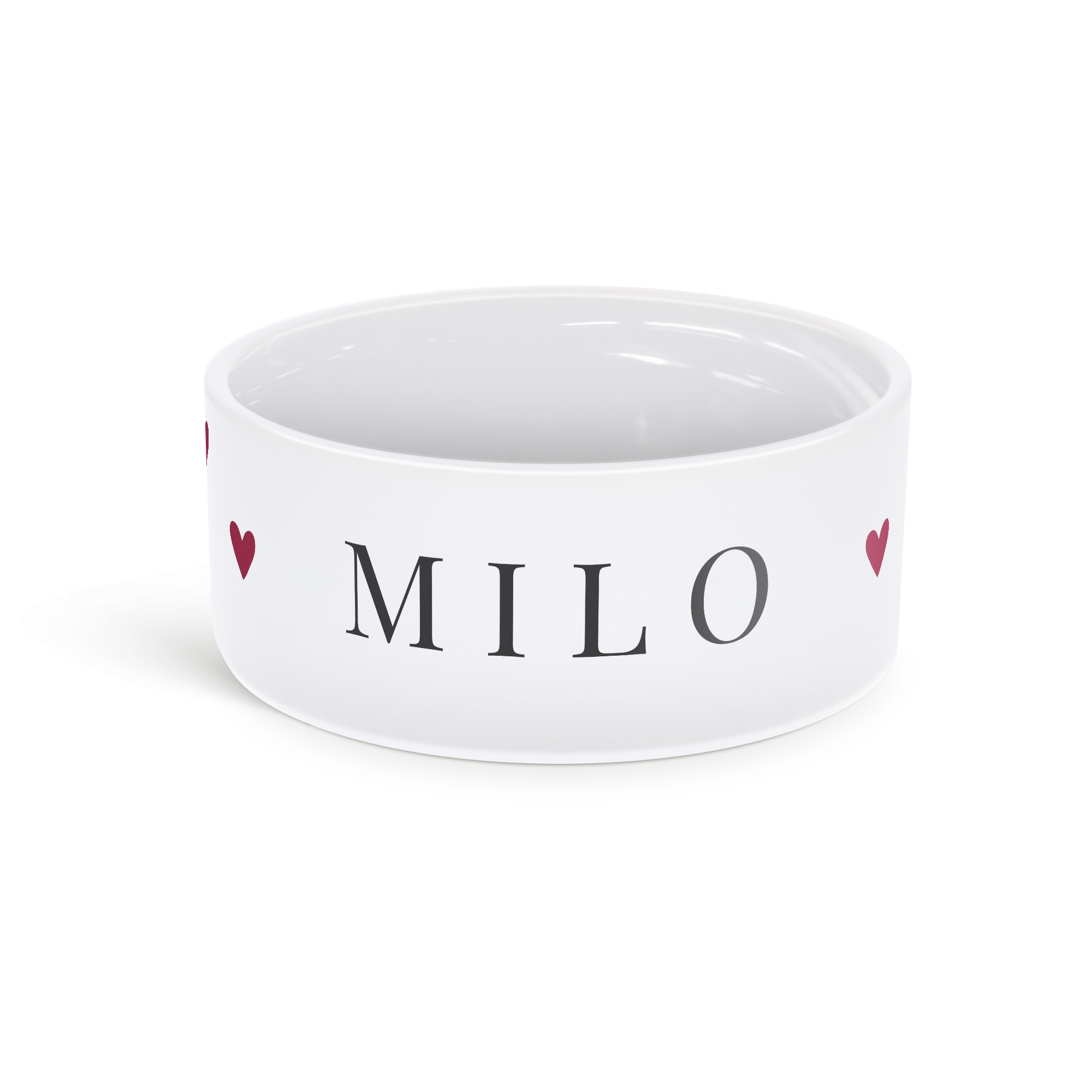 Valkoinen keraaminen lemmikkiruokakulho, jossa on mustalla tekstillä nimi MILO ja punaisia sydämiä ympärillä. Tee ateriaajasta erikoista räätälöidyllä lemmikkiruokakulholla.