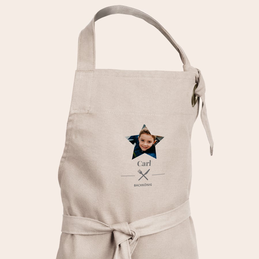 Kinderschürze personalisiert Personalisierte Kinderschürze in Beige mit einem Foto von Carl in einem Stern und dem Text Backkönig