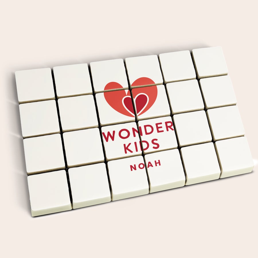 Foto en bloques de chocolate Chocolates personalizados con un corazón rojo y el texto "Wonder Kids Noah" impreso.