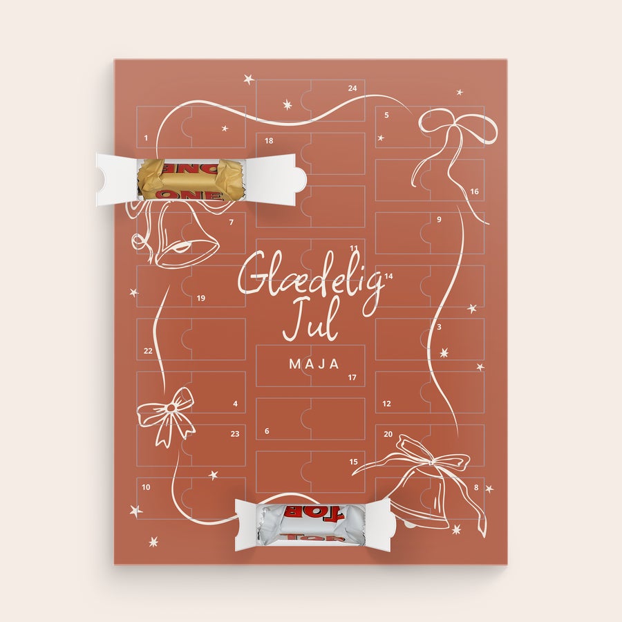 Chokolade julekalender - Toblerone 2025 En personlig Toblerone julekalender i rødbrun med påtrykt Glædelig Jul Maja, med to åbne låger der viser Toblerone chokolade. Tæl ned til jul med denne personlige Toblerone julekalender.