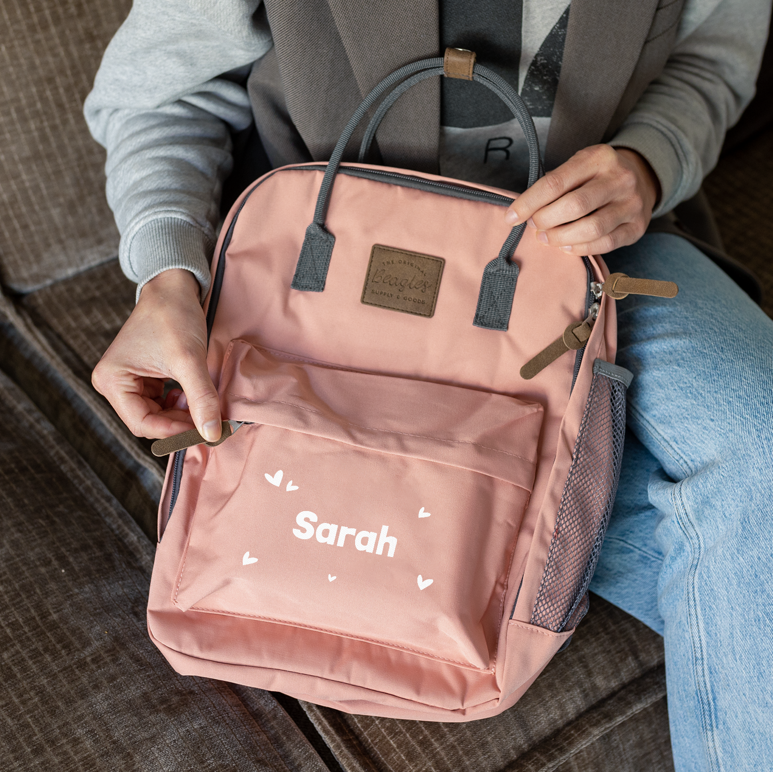 Růžový personalizovaný batoh se jménem Sarah a bílými srdíčky, potištěný na přední kapse