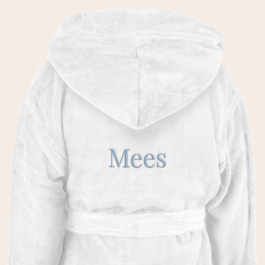Badjas kind met naam Witte kinderbadjas met capuchon, geborduurd met de naam Mees in blauw lettertype. Verras een kleintje met een superzachte kinderbadjas met naam.