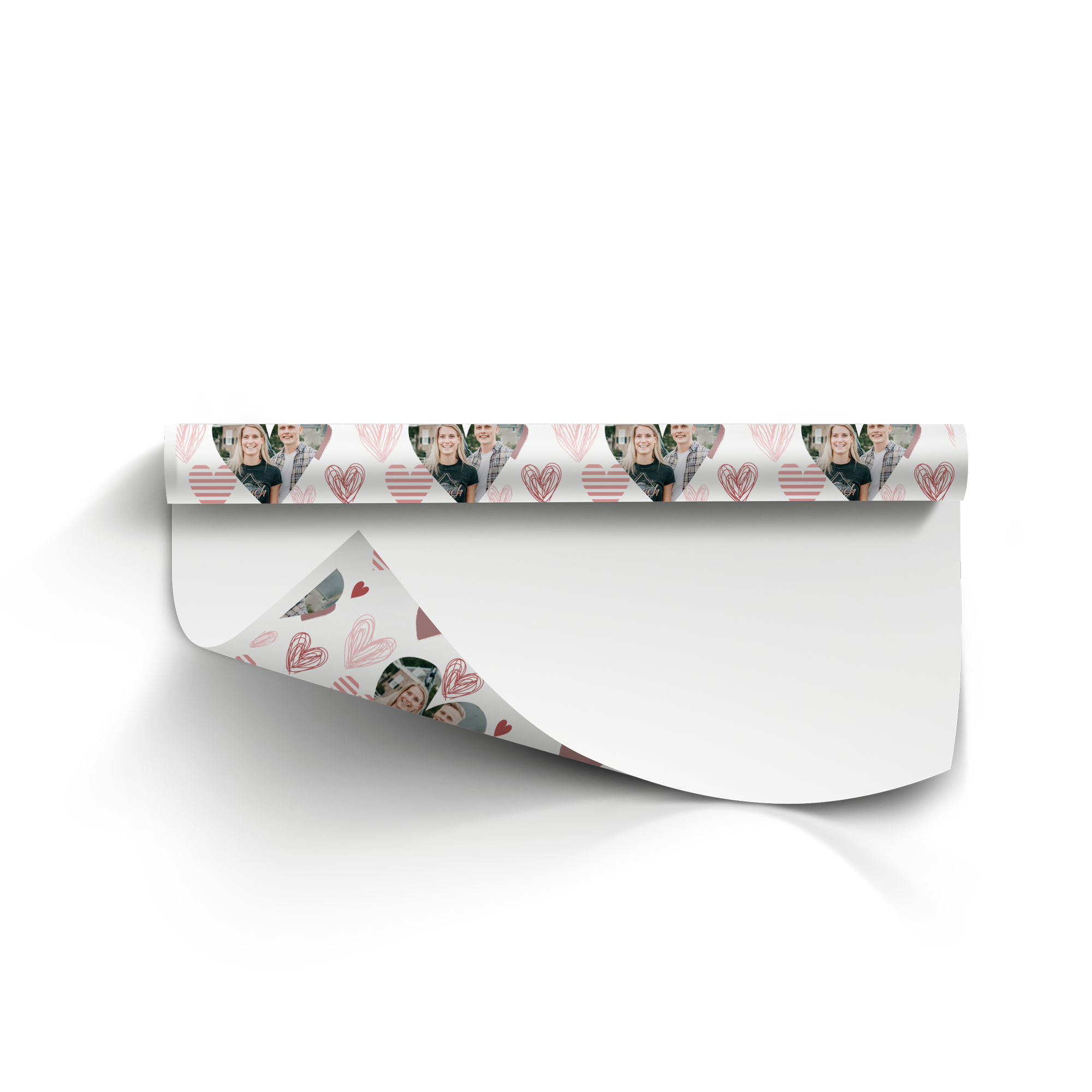 A roll of personalised wrapping paper with a repeating pattern of couple photos and drawn hearts printed on it.