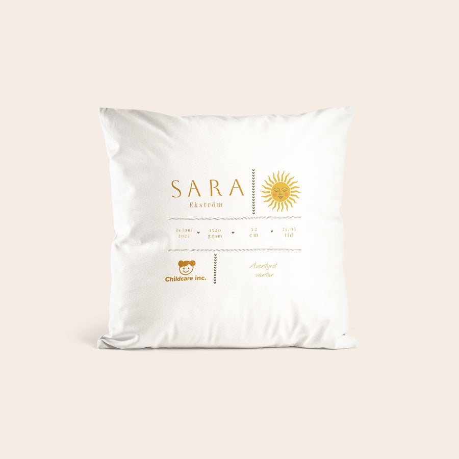 Födelsekudde med tryck - Vit Vit kudde med tryckt solsymbol och texten Sara Ekström, 24 juni 2025, samt Äventyret väntar.