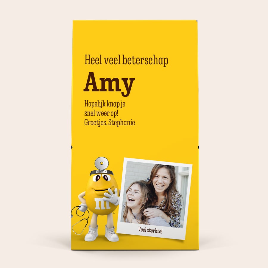 XL M&M's box personaliseren - 6 zakjes (714 gram) Gepersonaliseerde XL M&M's chocolade box met de tekst "Heel veel beterschap Amy", een dokter M&M, en een foto van twee lachende vrouwen.