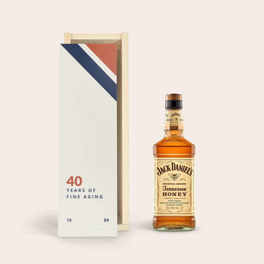 Jack Daniels Honey Bourbon személyre szabott dobozban Egy egyedileg nyomtatott díszdoboz Jack Daniels Honey whiskyjével, fehér, piros és kék dizájnnal, "40 YEARS OF FINE AGING 1984" felirattal