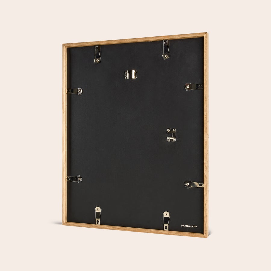 Personalised photo print with frame Back of a personalized photo print with a light wooden frame, featuring hooks for hanging.