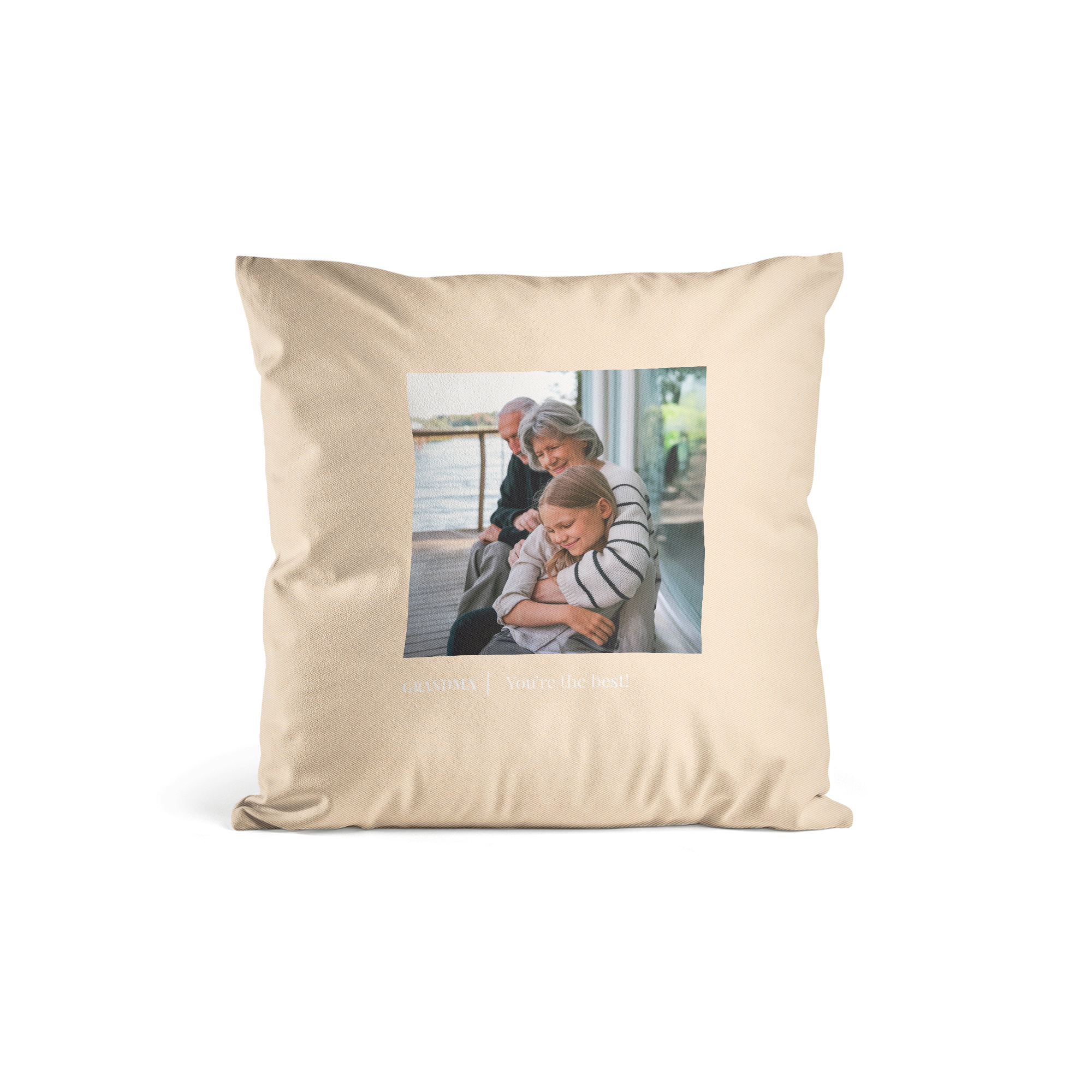 Almofada personalizada bege com foto impressa de uma avó abraçando a neta e o texto "GRANDMA You're the best!". Transforme qualquer espaço com uma almofada lindamente personalizada.