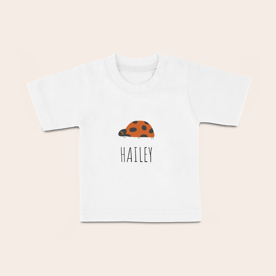 Baby t shirt bedrucken Weisses Baby T-Shirt mit Marienkäfer-Motiv und dem Namen Hailey, gedruckt mit individuellem Namen