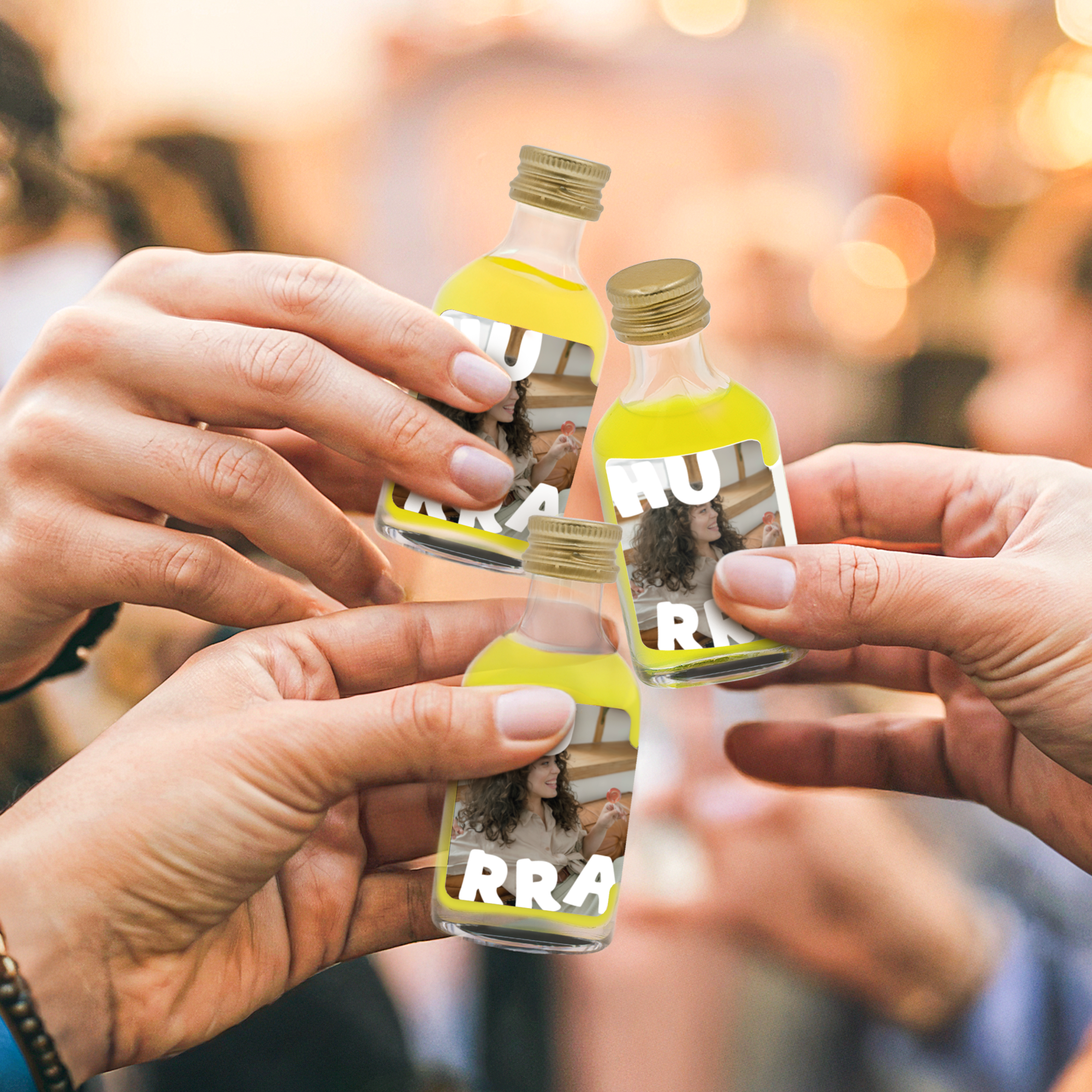 Tre hænder, der skåler med personlige mini-limoncello flasker med trykt billede af en kvinde og teksten HURRA. Skab en unik mini Limoncello-kollektion specielt til dem.