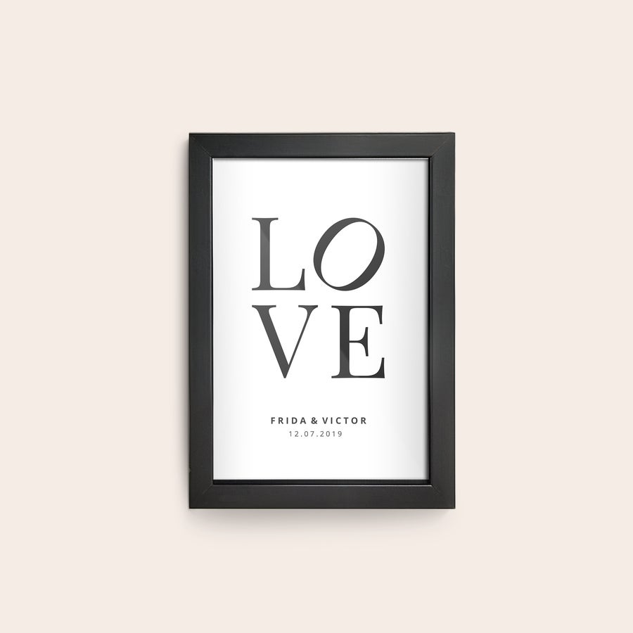 Personlig plakat i ramme Personlig plakat med sort træramme og ordet LOVE samt tekst “FRIDA & VICTOR 12.07.2019” trykt på.