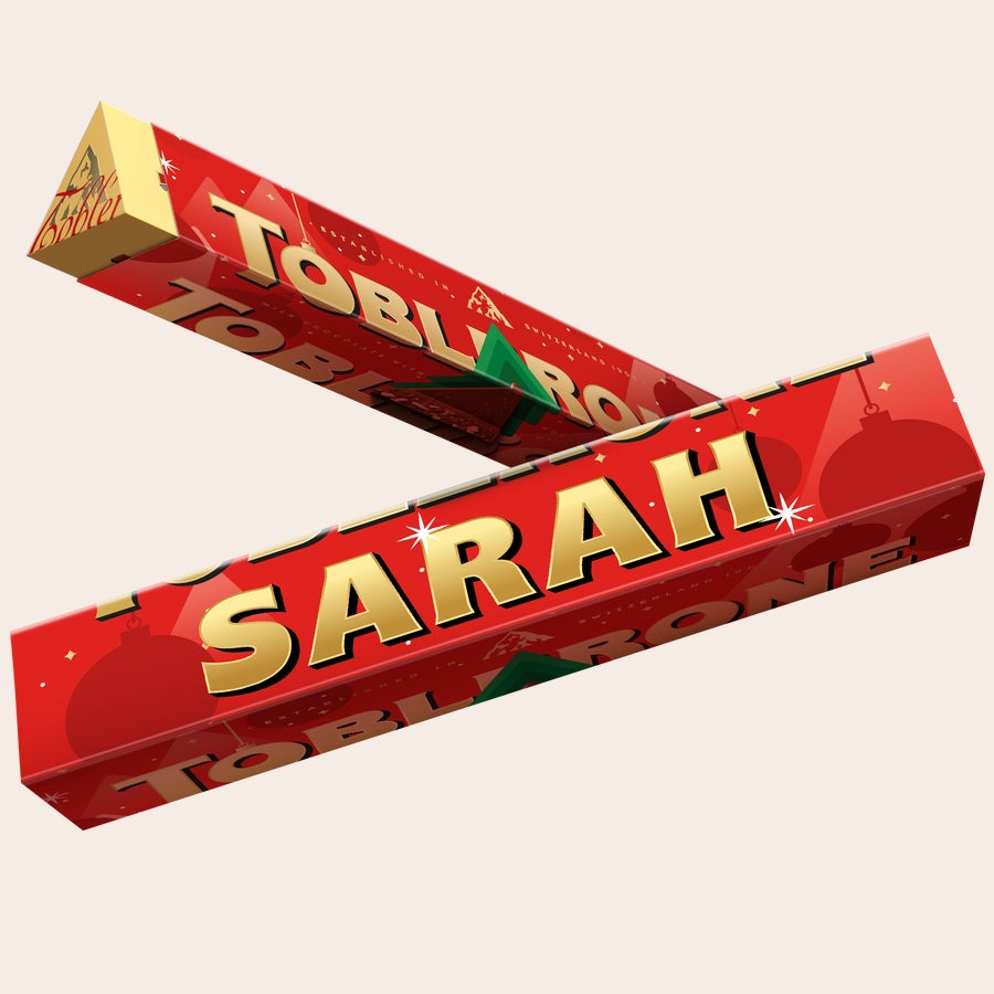 Toblerone Personalizado - Natal Barra de Natal Toblerone vermelha personalizada com nome Sarah, decorada com flocos de neve e árvores, para desejar um Feliz Natal