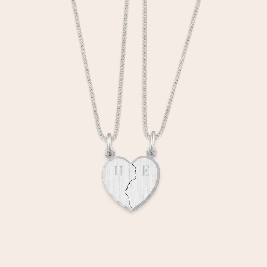 Pendentif en argent gravé - cœur brisé Pendentif coeur sécable en argent gravé avec deux initiales H et E sur ses moitiés personnalisables