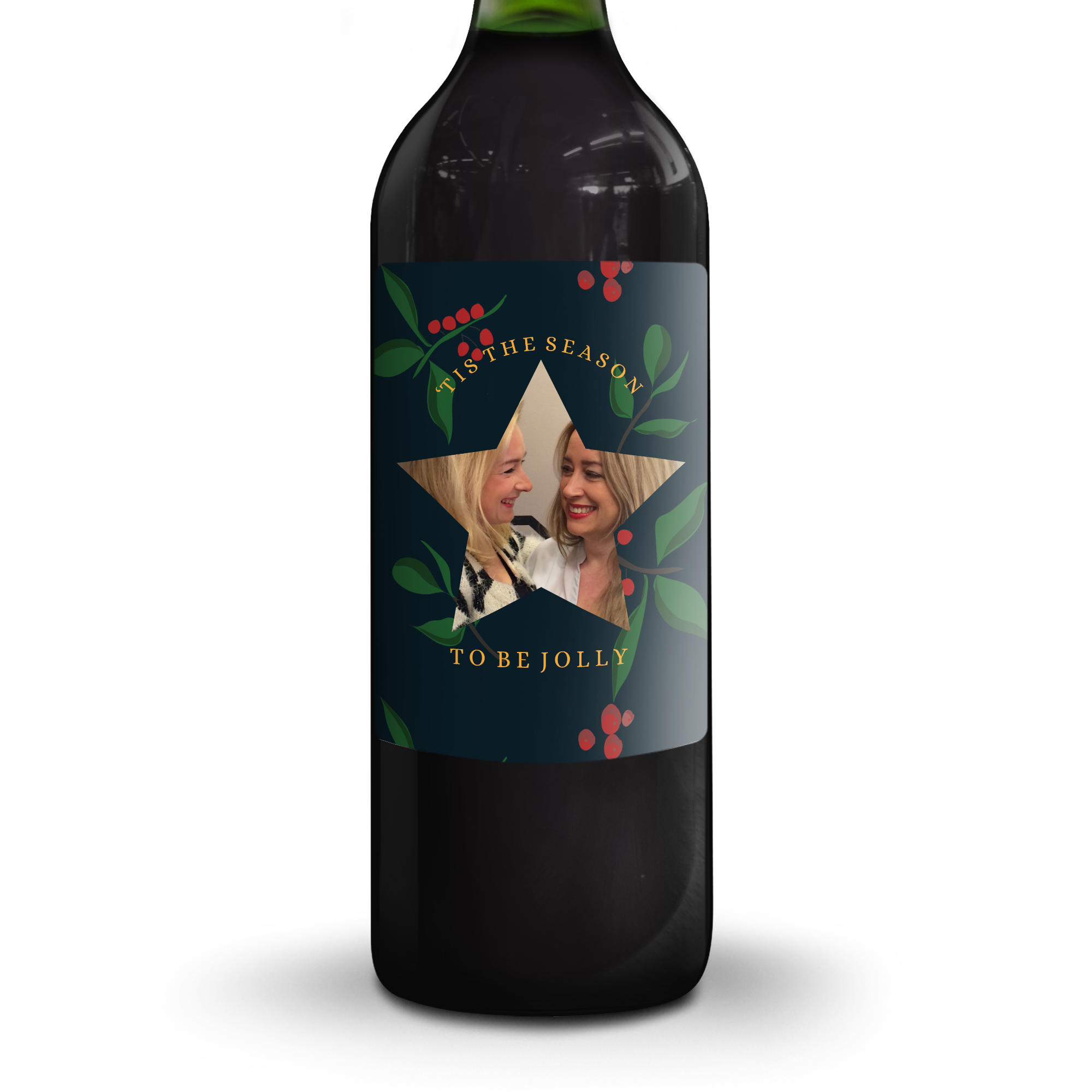 Butelka glühwein z etykietą ze zdjęciem dwóch kobiet, napisem Tis The Season To Be Jolly i wzorem z ostrokrzewem