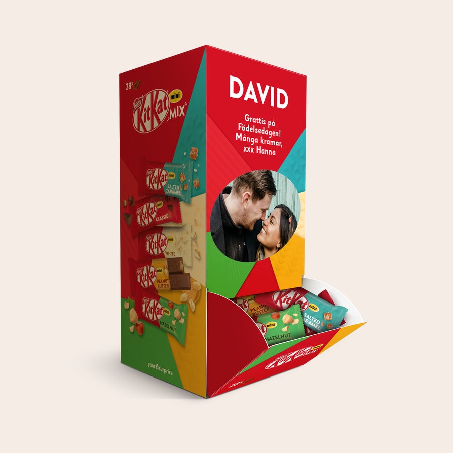 Personlig KitKat Mini Mix-presentask Personlig KitKat chokladmixlåda med 28 KitKat-minichokladbitar. Lådan är tryckt med ett personligt foto och hälsningen David Grattis på Födelsedagen Många kramar xxx Hanna. Överraska dina nära och kära med personlig KitKat-choklad.