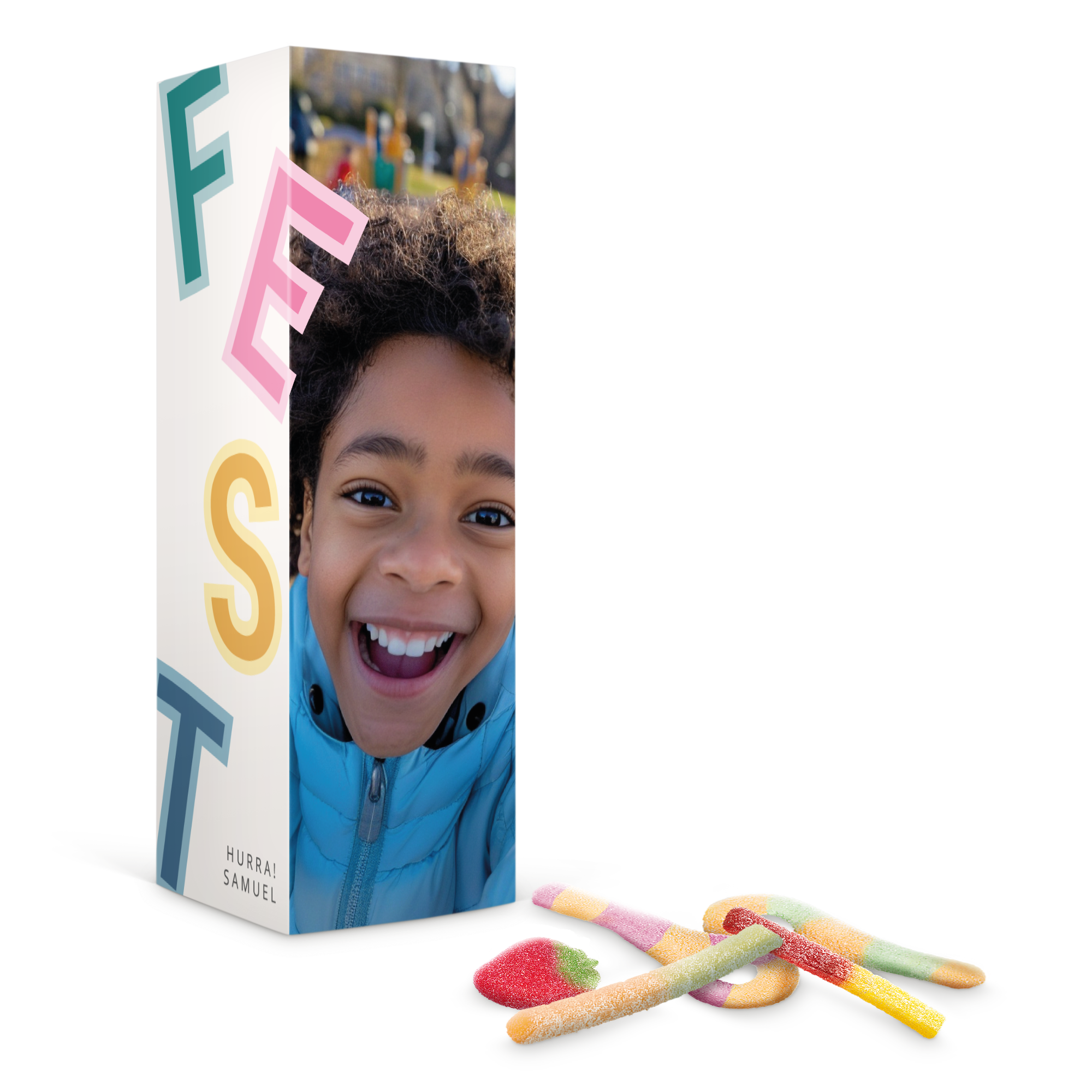 Personalisierte Süßigkeiten-Geschenkbox mit dem Foto eines lachenden Kindes und dem Text HURRA SAMUEL aufgedruckt, daneben Gummibärchen.