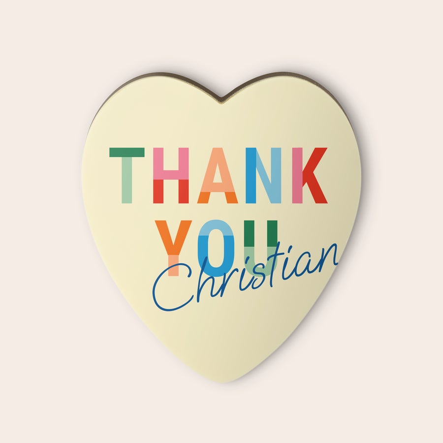 Chokladhjärta med tryck Vitt chokladhjärta med texten THANK YOU i olka färger och namnet Christian tryckt med blå kursiv stil, låt kärleken ta vägen genom magen med ett personligt chokladhjärta