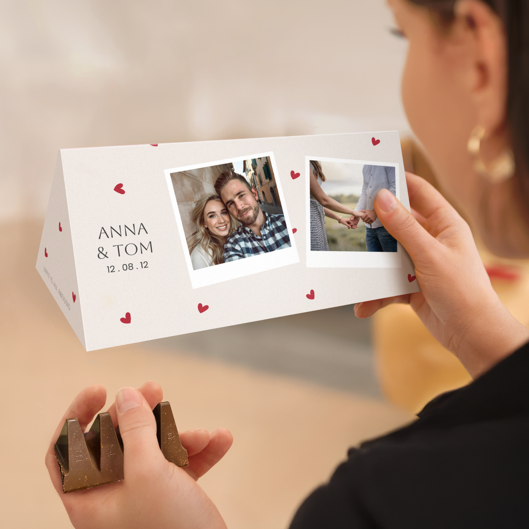 Eine personalisierte XL Toblerone mit individuellem Druck von Namen und Fotos, umrandet von roten Herzen.