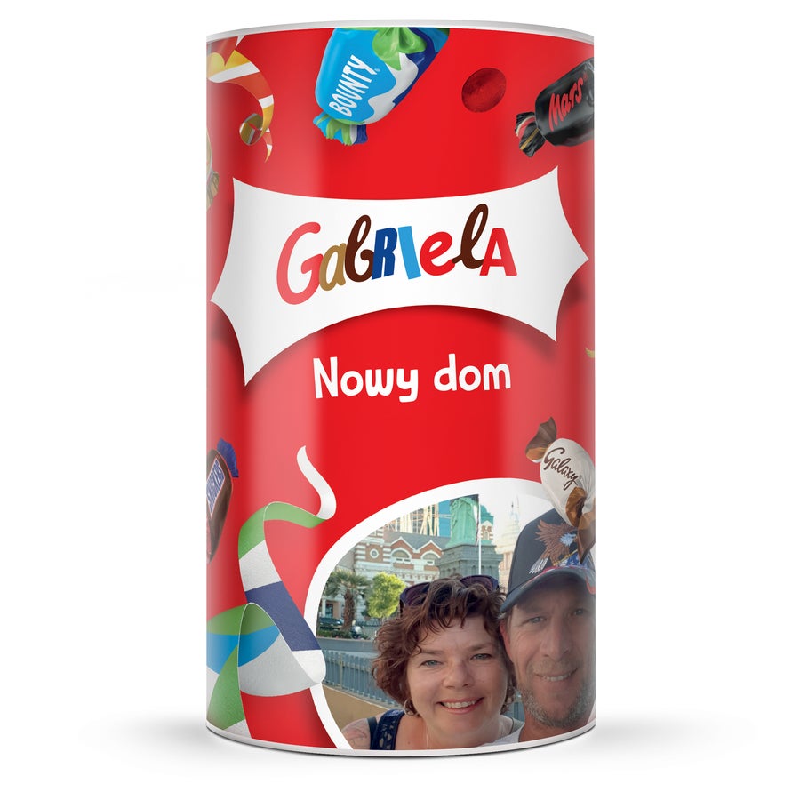 Cukierki Celebrations w personalizowanej tubie Czerwona tuba okolicznościowa z cukierkami, personalizowana imieniem Gabriela, napisem Nowy dom i zdjęciem pary