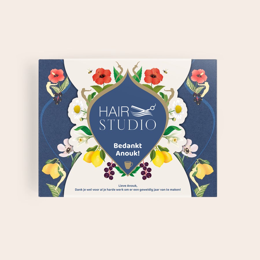 Pukka thee personaliseren Gepersonaliseerde theedoos met bloemendessin, "Hair Studio" logo, en de tekst "Bedankt Anouk!" met een theemoment afbeelding.