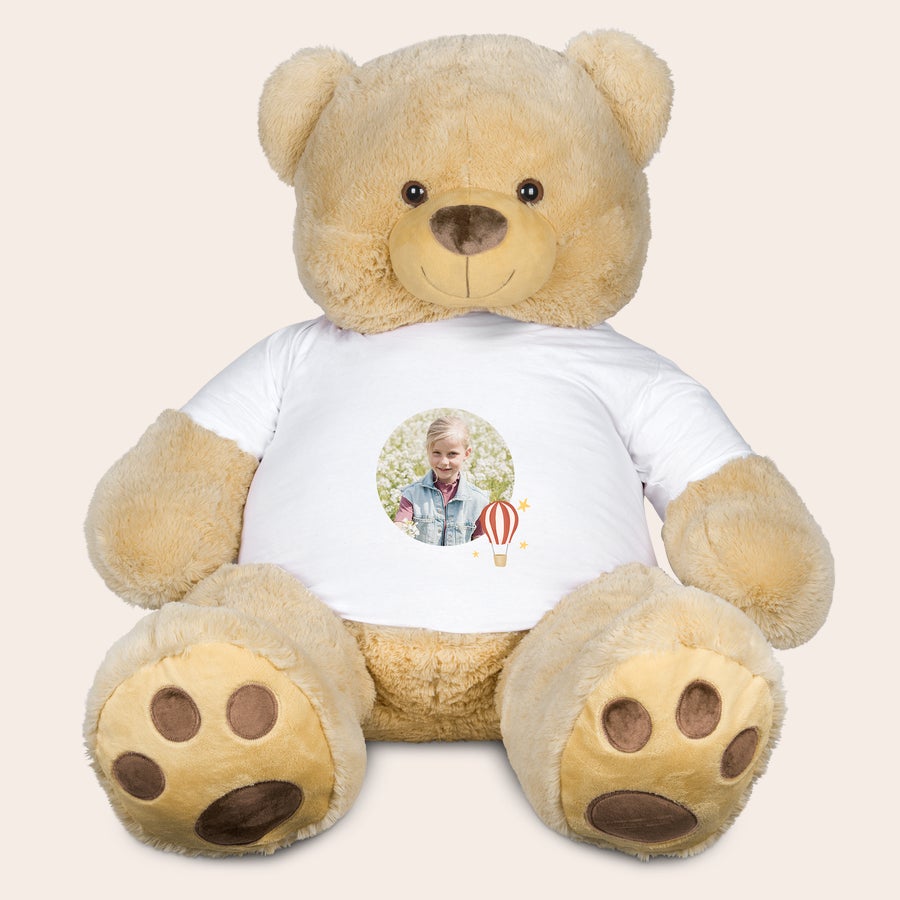 Kæmpe bamse med t-shirt med print - 130 cm! Kæmpe bamse med t-shirt med print af en glad pige og en varmluftsballon til dejlige krammere.