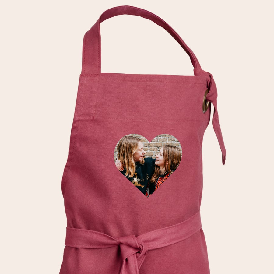 Children's Apron Childrens personalized apron in red with a heart-shaped photo of two smiling girls printed on the front.