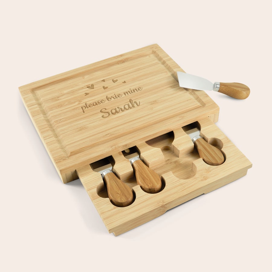Set cadou tabla cu branza gravata din lemn Set cadou personalizat de tabla de branza din bambus, gravat cu textul "please brie mine Sarah" și 4 ustensile.