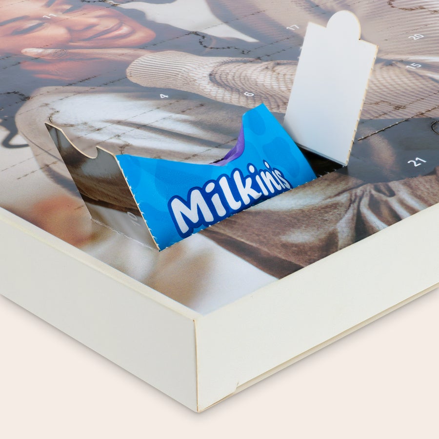 Milka Favourites Adventskalender 2025 Personalisierter Adventskalender mit eigenem Foto, ein geöffnetes Türchen zeigt Milka Schokolade. Zähl bis Weihnachten runter mit diesem personalisierten Adventskalender.