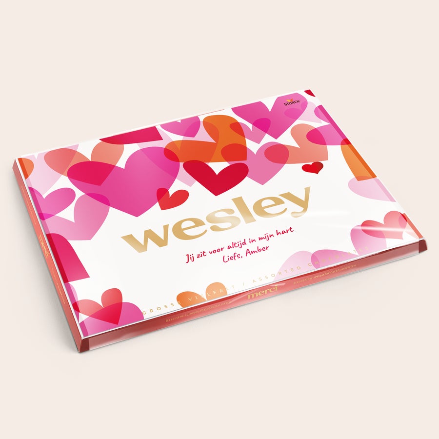 merci Finest Selection met kaart Merci Finest Selection chocolade mix met gepersonaliseerde kaart - 675 gram, bedrukt met naam Wesley en persoonlijke boodschap Jij zit voor altijd in mijn hart, Liefs, Amber, op een achtergrond van roze en rode hartjes