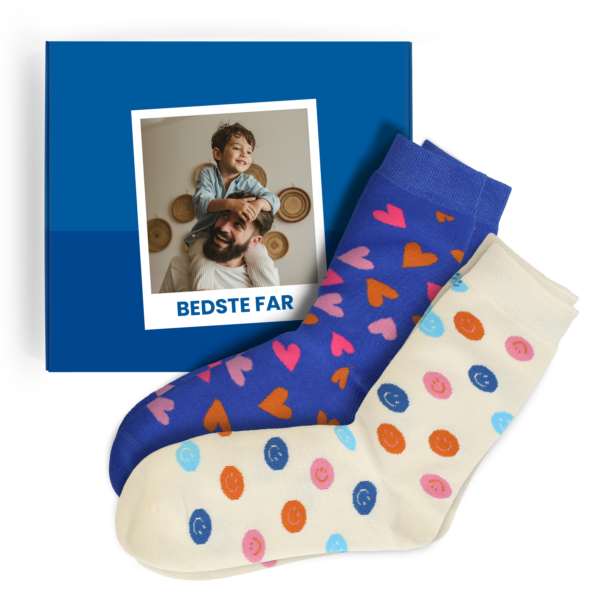 Personaliseret gaveæske med sokker – 2 par sokker – 43/46. Blå æske med personligt printet billede af far og søn samt teksten BEDSTE FAR. Den ene sok er blå med farverige hjerter, den anden cremefarvet med farverige smileys.