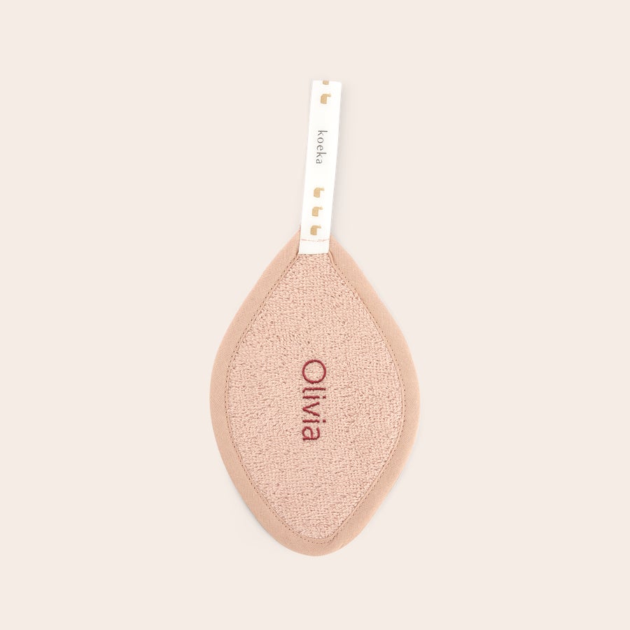 Pânză personalizată pentru manechin - Koeka O cârpă de manechin personalizată roz, brodată cu numele Olivia, cu etichetă Koeka.