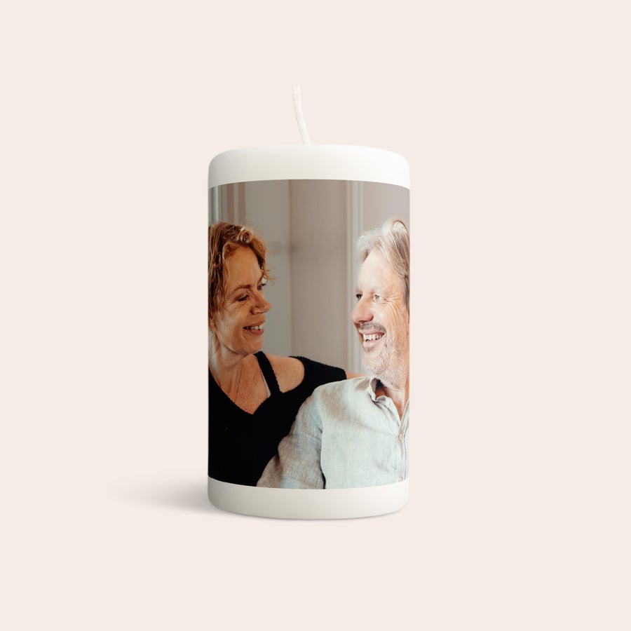 Candela con stampa Candela personalizzata bianca con foto di una coppia che sorride stampata attorno.