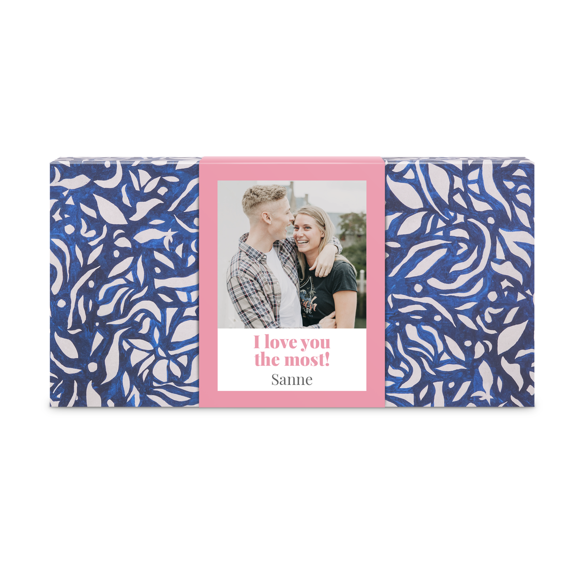 Waan je in een thuisspa met dit luxe verzorgingspakket. De cadeaudoos met blauw en wit patroon heeft een roze gepersonaliseerde sleeve met een foto van een stel en de tekst "I love you the most! Sanne".