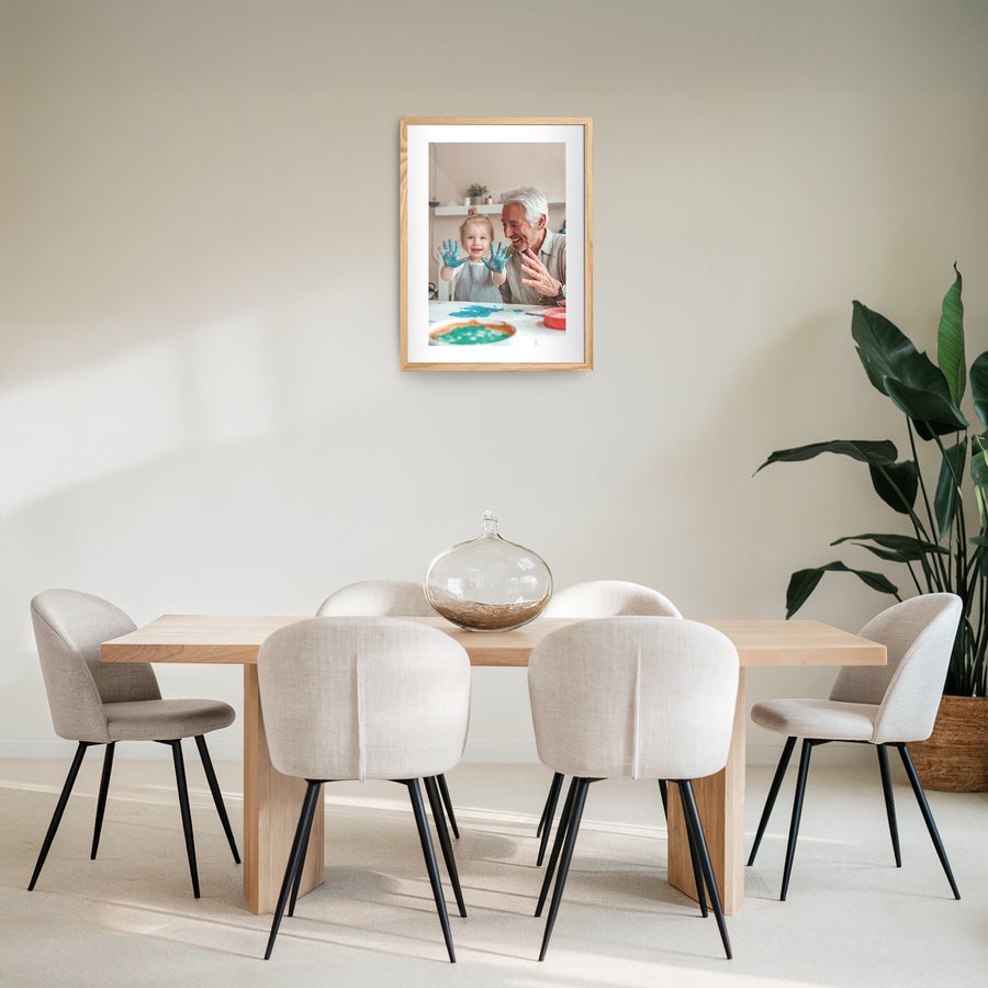 Innrammet bilde Bilde på veggen med personlig foto, trykt og innrammet i eik, viser et barn og en mann med maling på hendene.