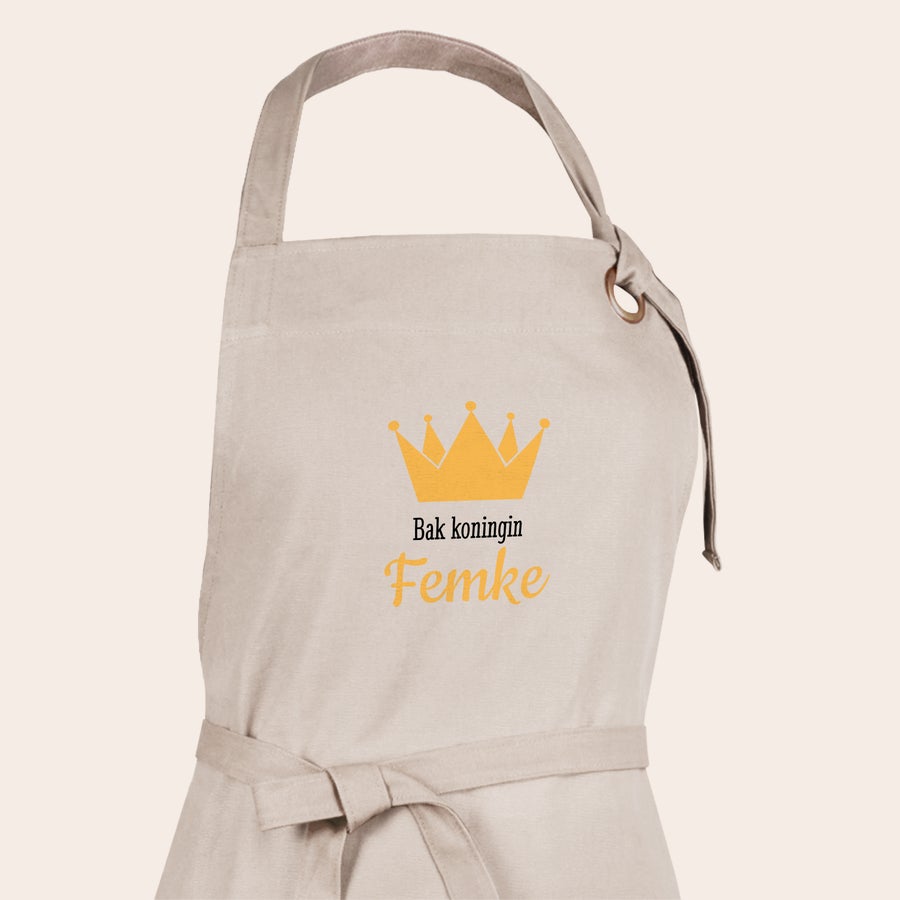 Schort met foto Lichtbeige keukenschort met een goudkleurige kroon en de bedrukte tekst 'Bak koningin Femke'