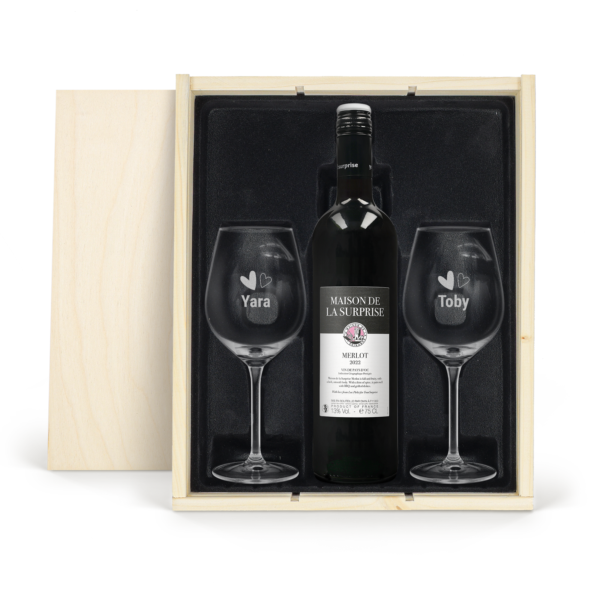 Maison de la Surprise Merlot vinpakke med indgraverede glas i et åbent træhus med navnene Yara og Toby