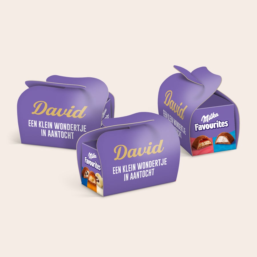 Milka favourites traktatie personaliseren Drie paarse Milka Favourites geschenkdoosjes met gepersonaliseerde naam David en tekst 'Een klein wondertje in aantocht'.