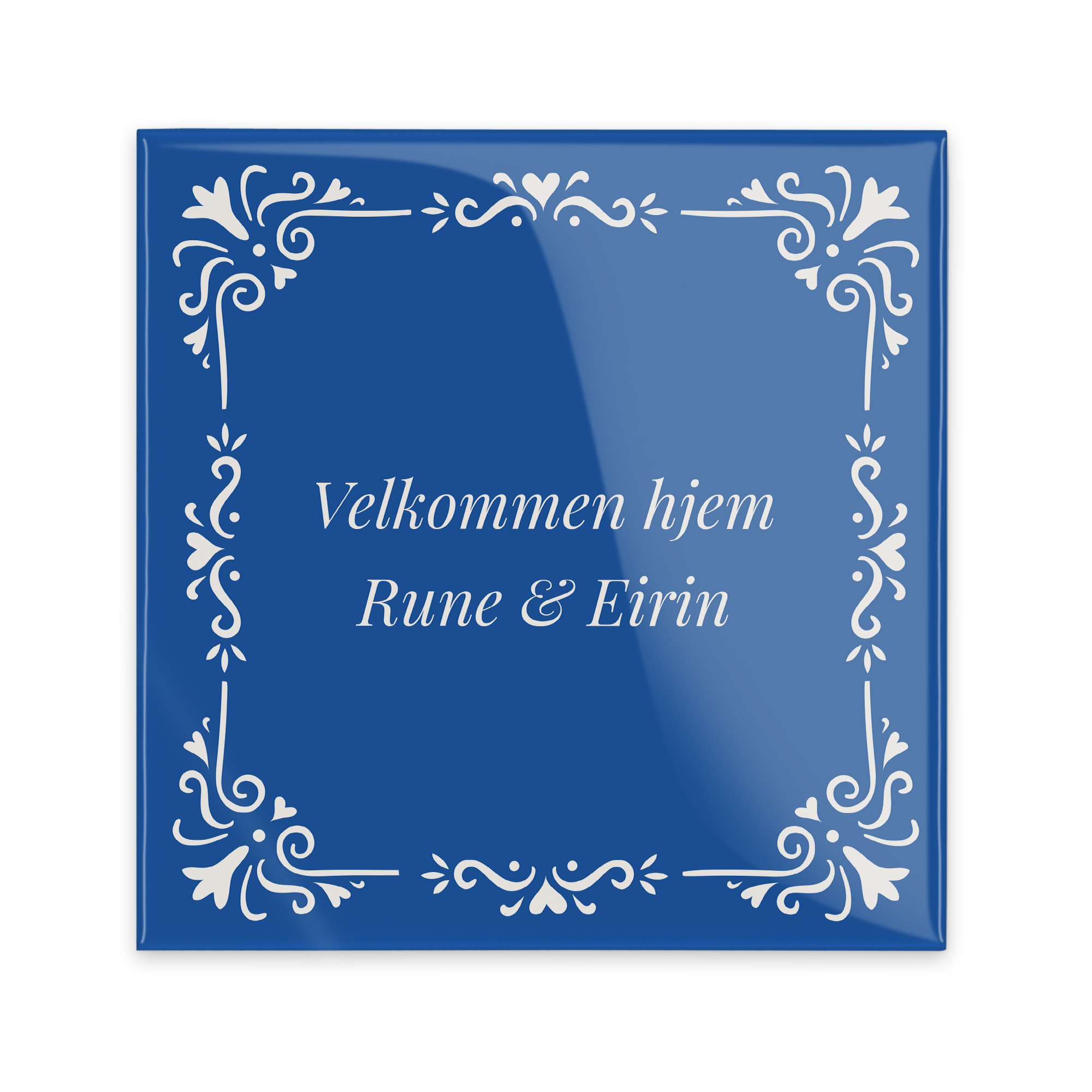 Blå keramisk flis med hvit dekorasjon, trykt med teksten "Velkommen hjem Rune & Eirin" som et personlig ordsprog.