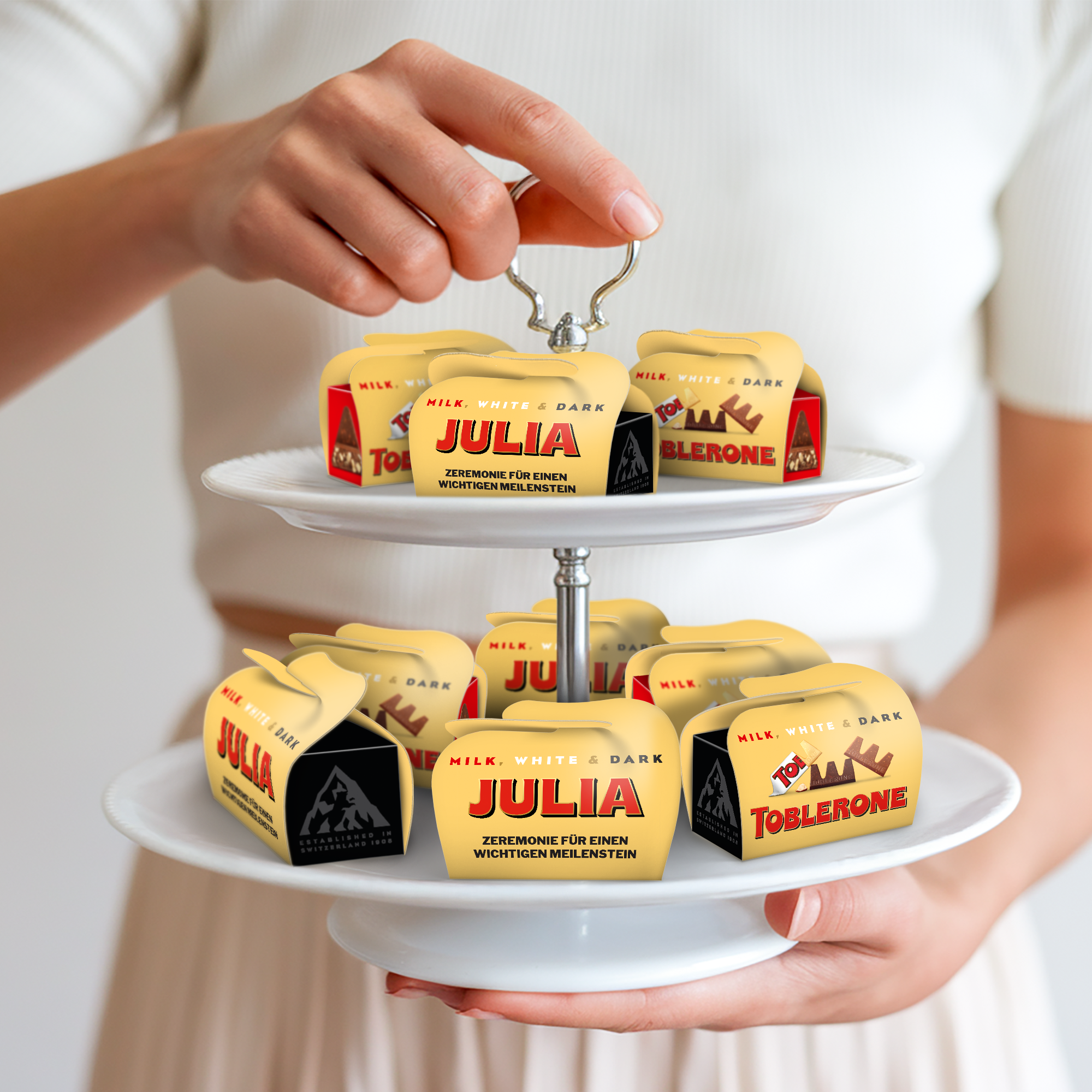 Personalisierte Mini-Toblerone-Geschenke mit dem Namen Julia und dem Text "Zeremonie für einen wichtigen Meilenstein" sind bedruckt.