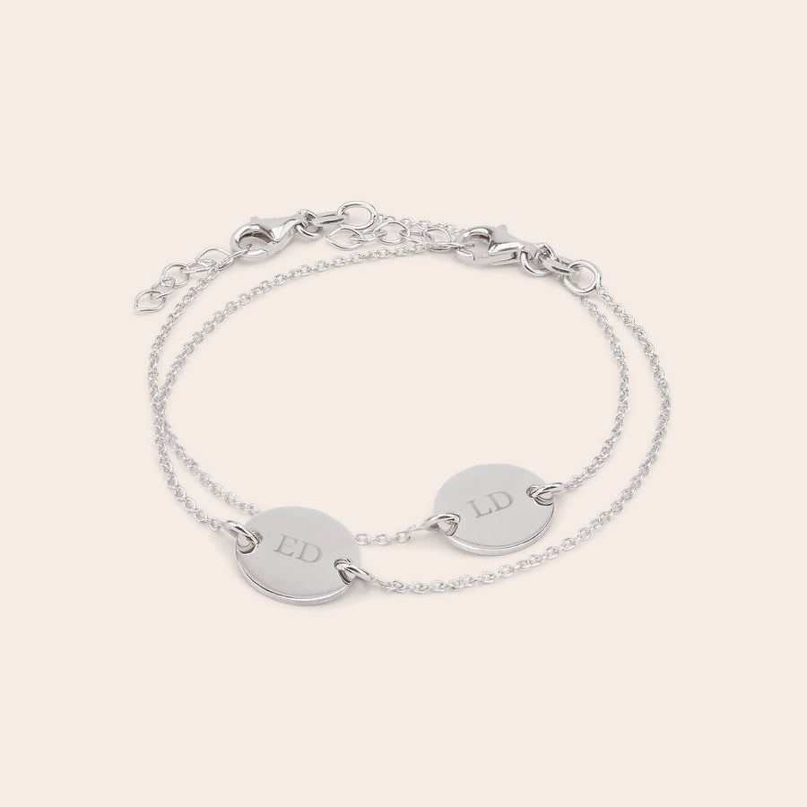 Indgraverede sølvarmbånd - mor og datter Et unikt sæt med mor og datter armbånd med indgraverede initialer "ED" og "LD" på runde sølvplader, der kan personliggøres.