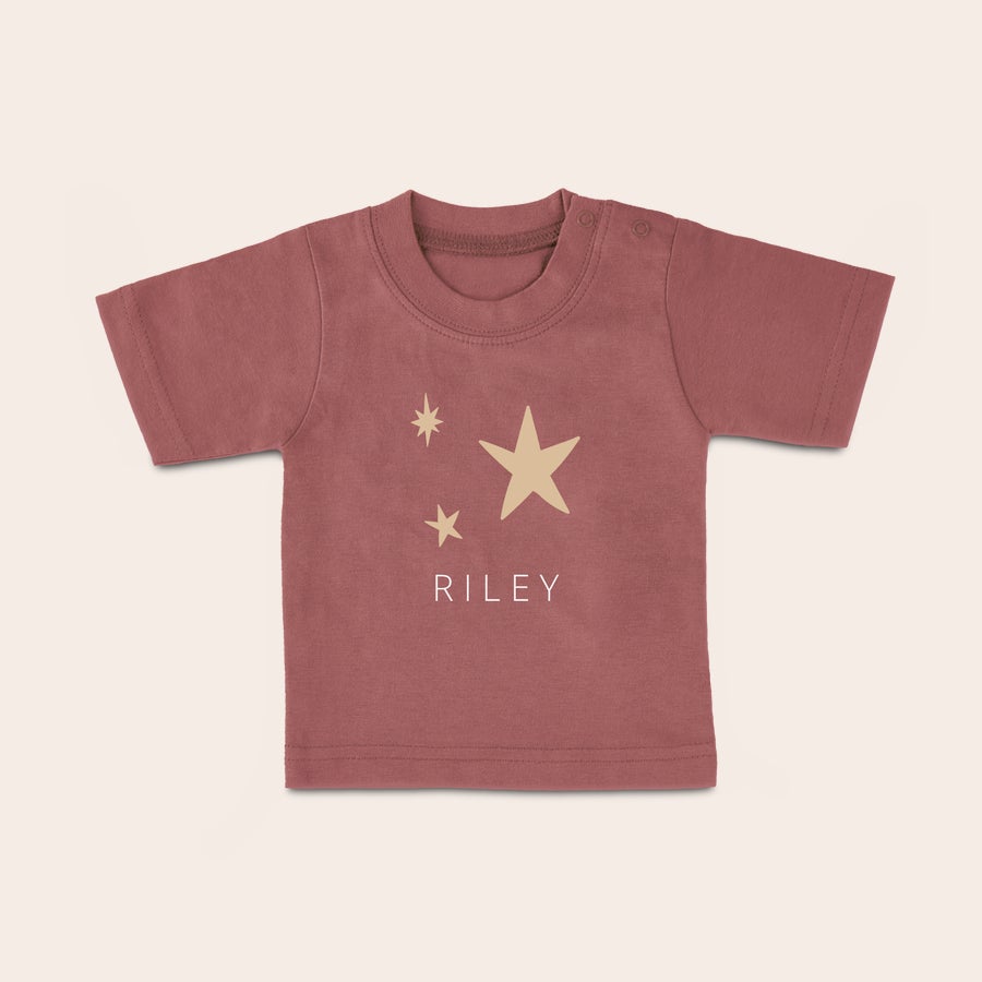 T-shirt feito sob encomenda do bebê T-shirt personalizada cor-de-rosa para bebé com nome Riley e estrelas impressas para vestir o seu pequeno com estilo.