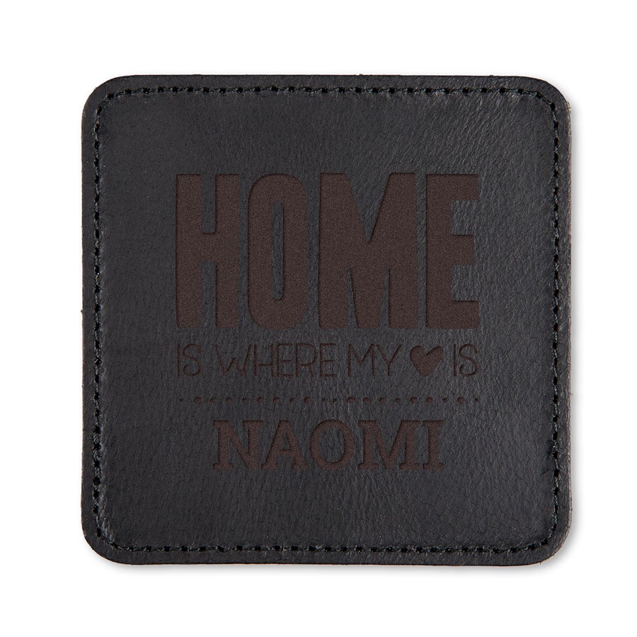 Leren onderzetter - Zwart gegraveerd met de tekst "HOME is where my (hartje) is" en de naam "NAOMI", volledig personaliseerbaar.