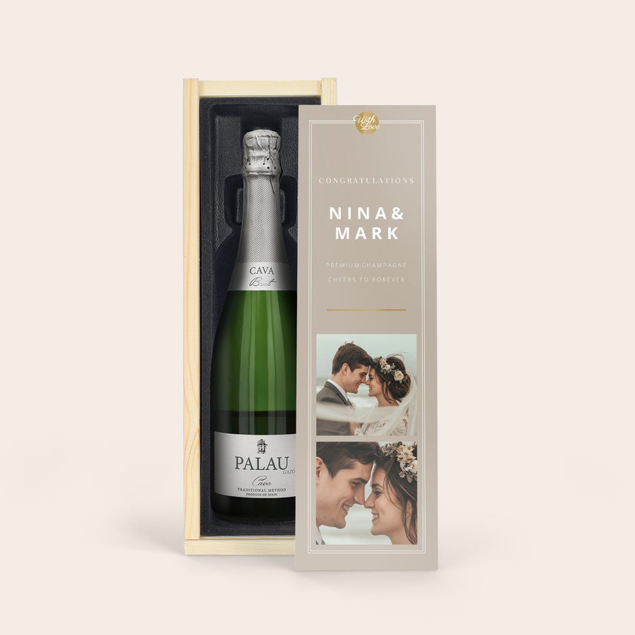 Personalised Wine Gift - Cava Palau Gazo Brut A bottle of Palau Gazo cava in a wooden case with a personalized sleeve showing "Nina & Mark" and two wedding photos.