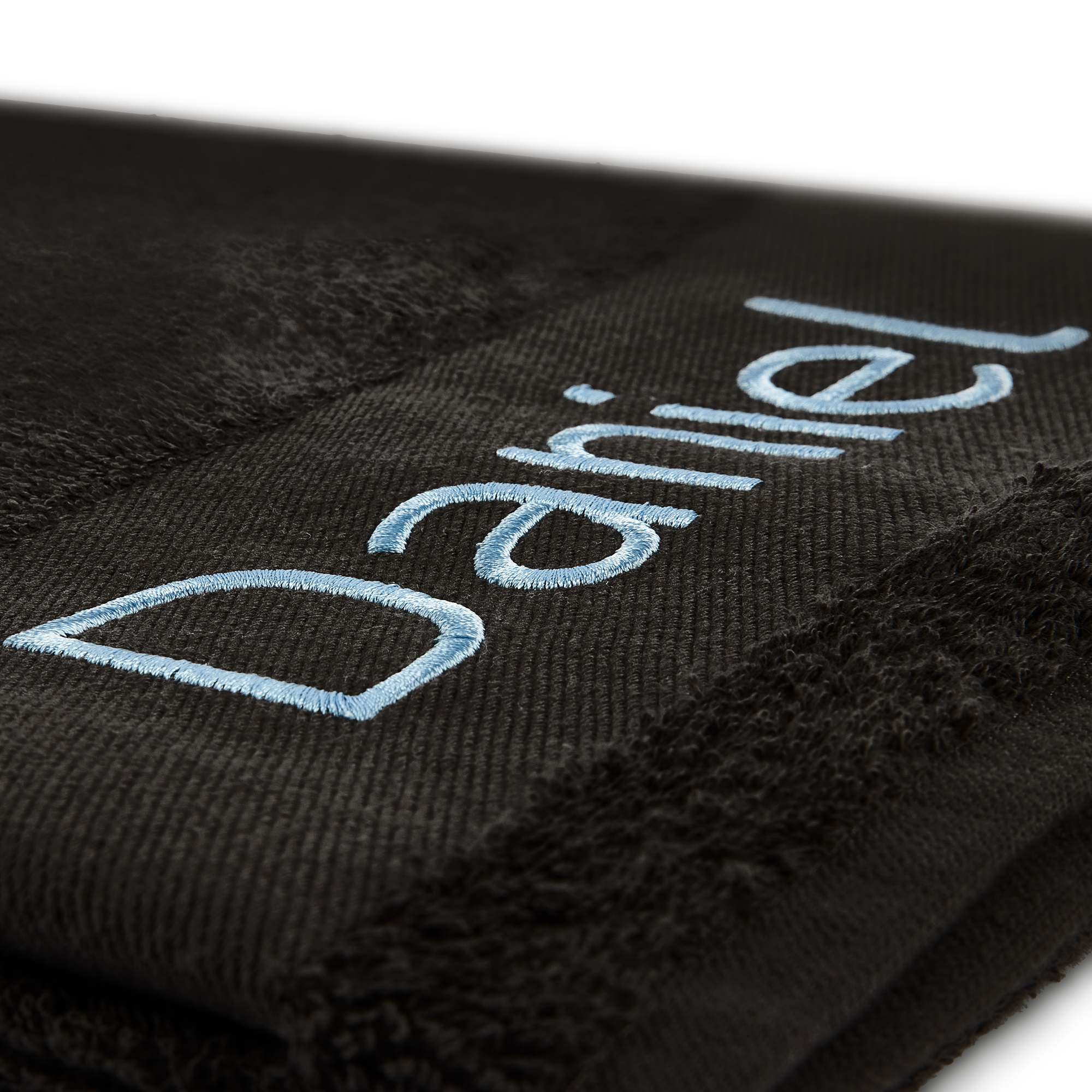 Personalized black bath towel embroidered with the name Daniel in light blue thread