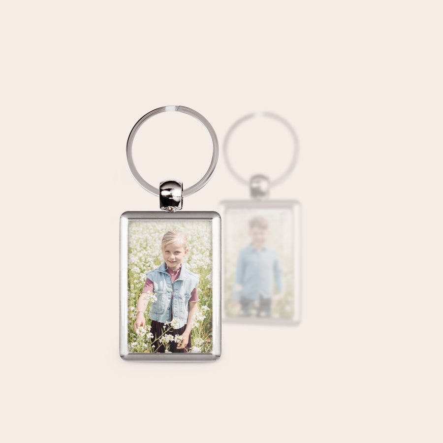 Breloc personalizat cu poză Breloc personalizat din oțel, imprimat față-verso cu o fotografie clară a unei fete și o fotografie estompată a unui băiat.