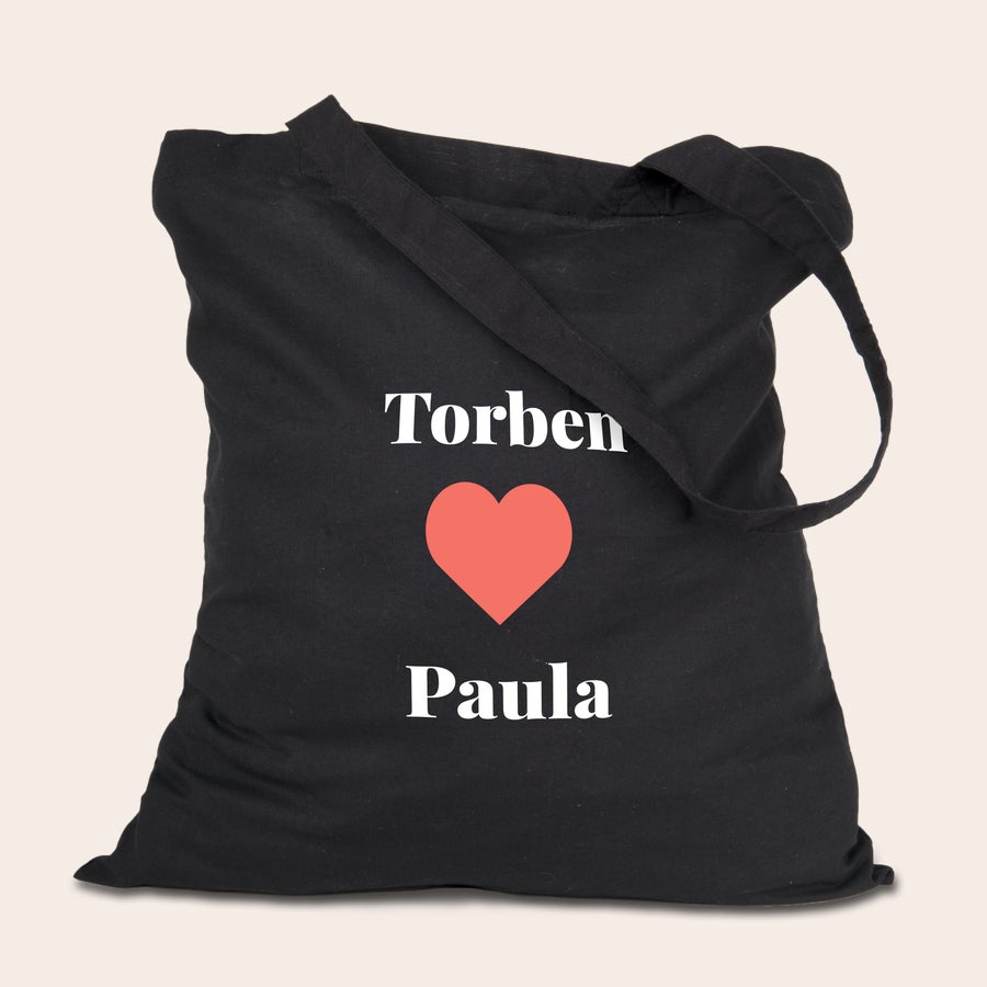 Jutebeutel Schwarzer Jutebeutel bedruckt mit den Namen Torben und Paula mit einem roten Herz dazwischen