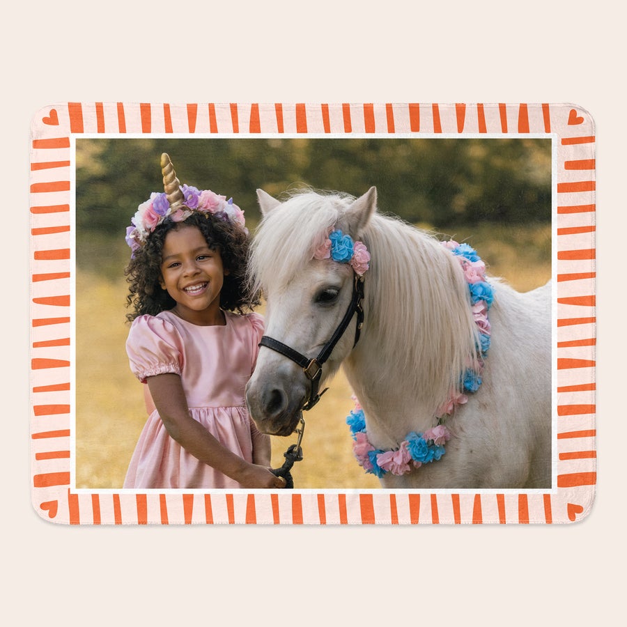 Manta con foto Manta de felpa impresa con foto de una niña sonriente y un poni blanco, ambos con adornos florales.
