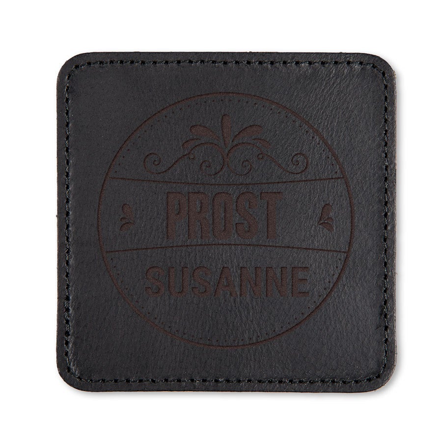 Schwarzer, gravierter Lederuntersetzer mit "Prost Susanne" Schriftzug und Ornamenten