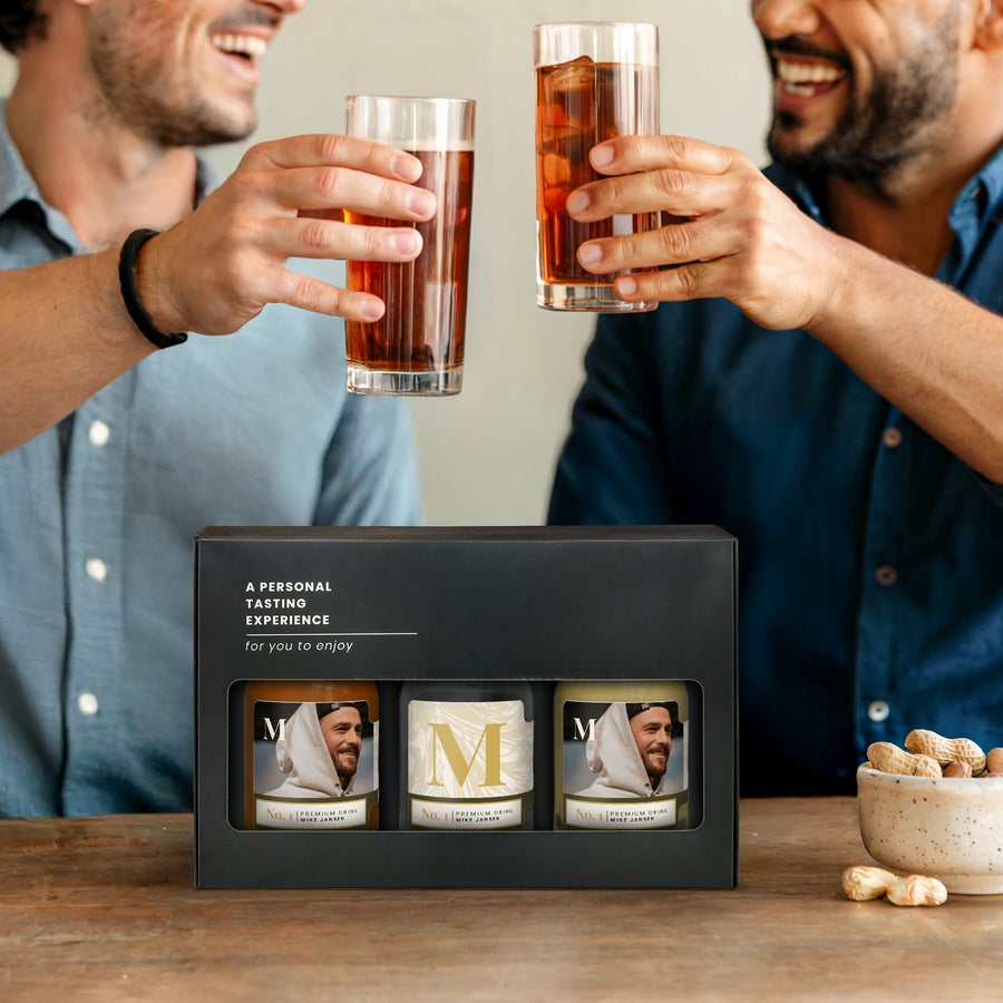 Miniatyralkoholprovning - Vodka - Rom - Whisky Personligt miniatyriserat alkoholprovningsset med tre flaskor, anpassade med foto och texten "Mike Jansen", presenteras i en svart låda.
